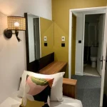 Petite chambre individuelle avec miroir et accès salle de bain à l’Hôtel Villa Berlioz Lyon