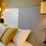 Bedding and wall lighting detail in a Comfort Room at Villa Berlioz Hotel Lyon