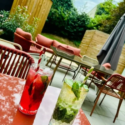 Verres de cocktails posés sur une table de terrasse dans le jardin de l’Hôtel Villa Berlioz Lyon