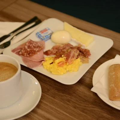 Savory breakfast with scrambled eggs, bacon, cheese and coffee at Hôtel Villa Berlioz Lyon