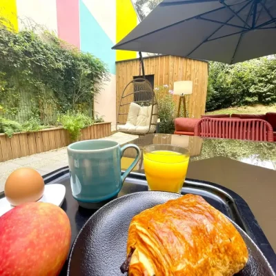 Breakfast with pastry and orange juice served on the terrace at Hôtel Villa Berlioz Lyon