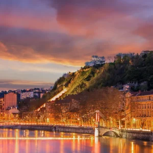 Quais de Saone a Lyon au crepuscule avec eglise, immeubles illumines et reflets sur l’eau