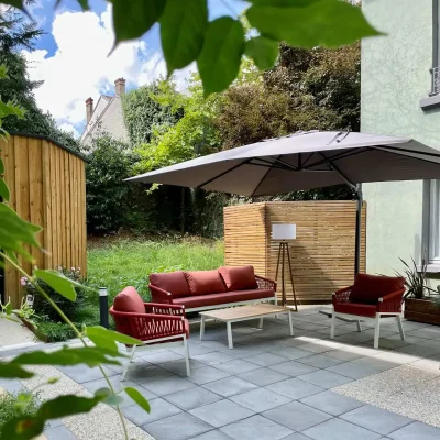 Salon de détente avec canapé et parasol sur la terrasse de l’Hôtel Villa Berlioz Lyon