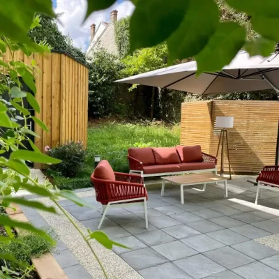 Salon de jardin avec canapé et fauteuils rouges sur la terrasse de l’Hôtel Villa Berlioz Lyon