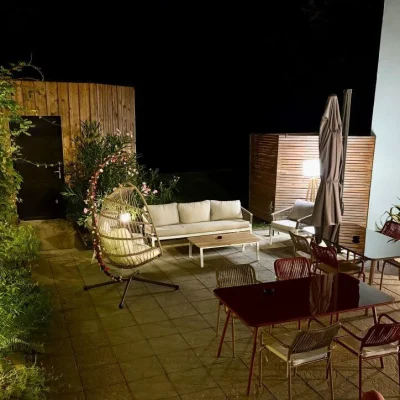 Terrasse éclairée de nuit avec mobilier extérieur à l’Hôtel Villa Berlioz Lyon