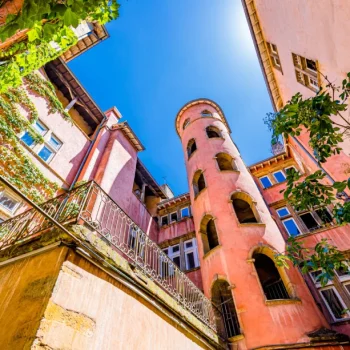 Cour interieure du Vieux Lyon avec traboule, tour rose, balcons et vegetation