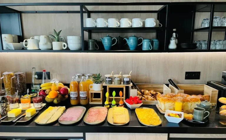 Breakfast buffet at Villa Berlioz Hotel in Lyon with pastries, cold cuts, cheese, fresh fruit and juices.
